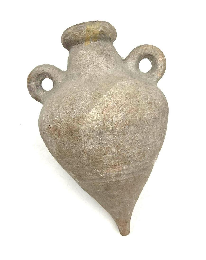 Amphora Pottery: This is believed to be an Amphora pottery with two handles possibly originating from the Greco-Roman era. It has a thick rim, and a tapered body that meets at a pointed bottom. This piece is in good -