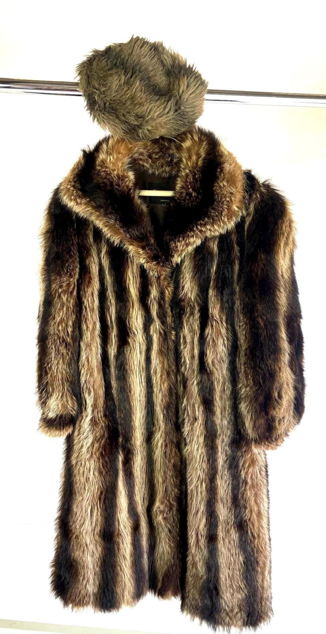 Fojurres Alexandor Furs Racoon Fur Coat and Cap: Fojurres Alexandor Furs Raccoon Fur Coat and Cap. They are believed to be crafted within the 20th century. The coat is believed to be made with raccoon fur, sits at knee length, and has a collar. The 