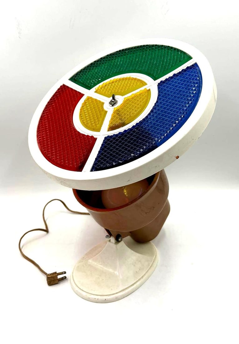 Vintage Red Blue Green and Yellow Rotating Light: Vintage Red Blue, Green, and Yellow Rotating Light. This is a Christmas Color Wheel Light. The light is made of plastic and has a rotating price on top with green, blue, yellow, and red filters. It’