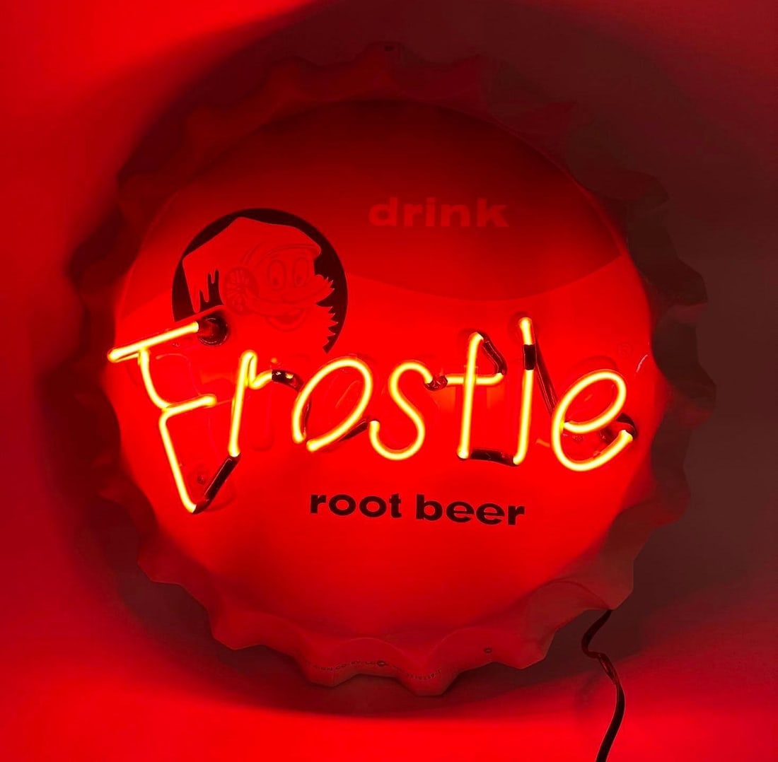 Frostie Root Beer Neon Sign: Frostie Root Beer Neon Sign. The sign is a bottle cap shape and is red, white, and blue with a Frostie character. The sign lights up when plugged in, and the word "Frostie" lights up.. Made by Stout S