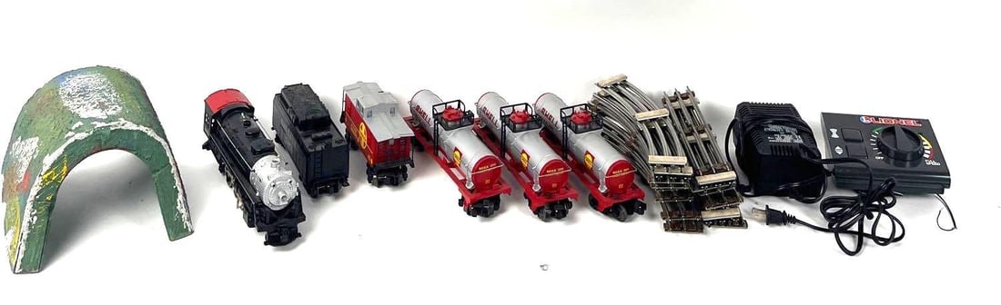 Lionel Train Set: Lionel Train Set. There are 6 train cars, railroad tracks, a tunnel, and a speed remote. The train cars have Lionel on the bottom side. Some have Santa Fe on the sides and others are Shell. The Shell