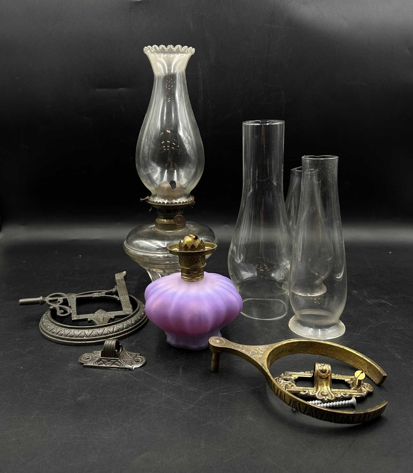 Glass Oil Lamps MFG Co Wall Attachments: Glass Oil Lamps MFG Co Wall Attachments. Includes a MFG. Co purple oil lamp base, believed to be from the mid to late 1800s. It's in good condition with some wear. It does have a shade but there are 3
