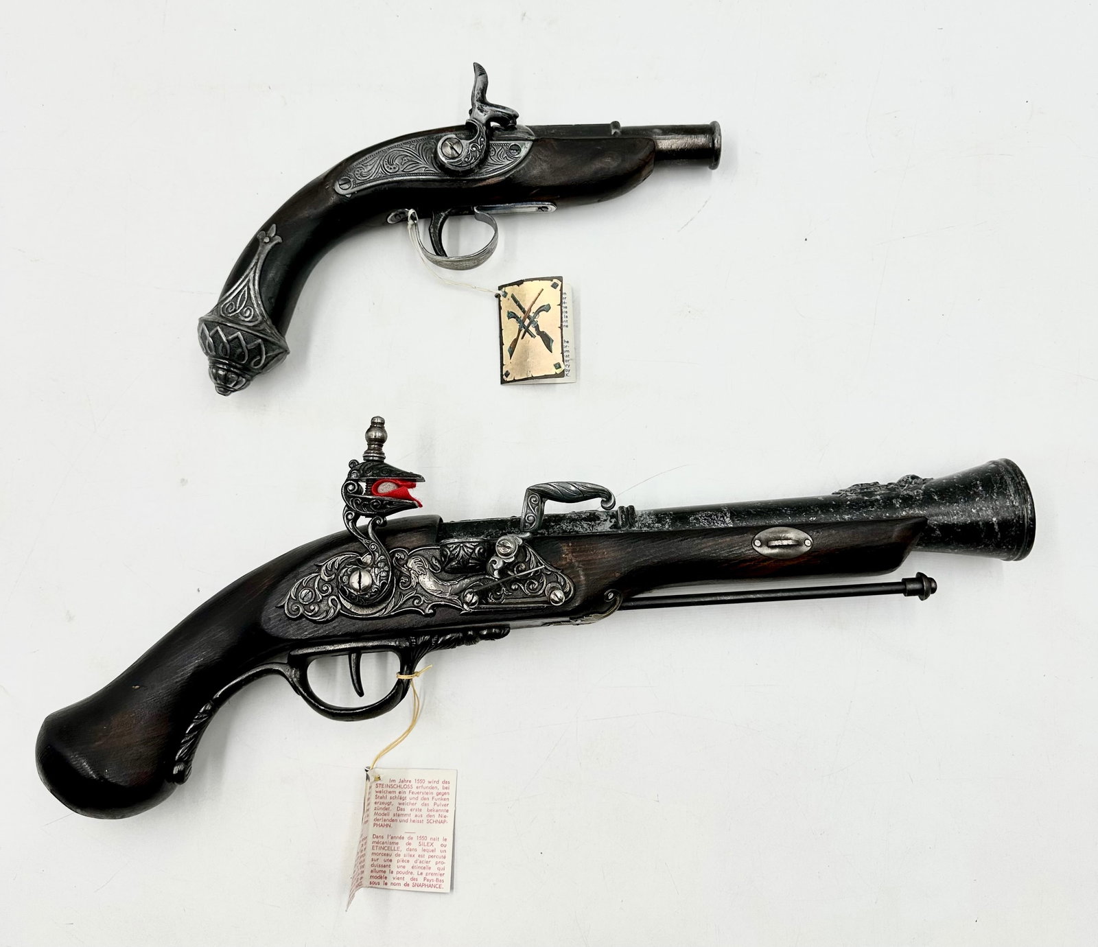 Replica Antique Snapchance Flint Lock Pistol and a replica Hammer Lock Pistol: Replica Antique Snapchance Flint Lock Pistol and a replica Hammer Lock Pistol. These guns are replicas and are in good condition, made in Spain. Includes a wooden and metal Flint-lock pistol replica o