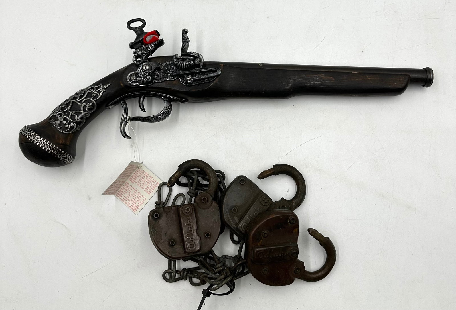 Replica Long Flint Lock Snaphance Pistol and 3 Vintage Adlake Railroad Padlocks: Replica Long Flint Lock Snaphance Pistol and 3 Vintage Adlake Railroad Padlocks. Includes a replica pistol that's long and is made of stained wood and metal accessories. It has intricate metal details