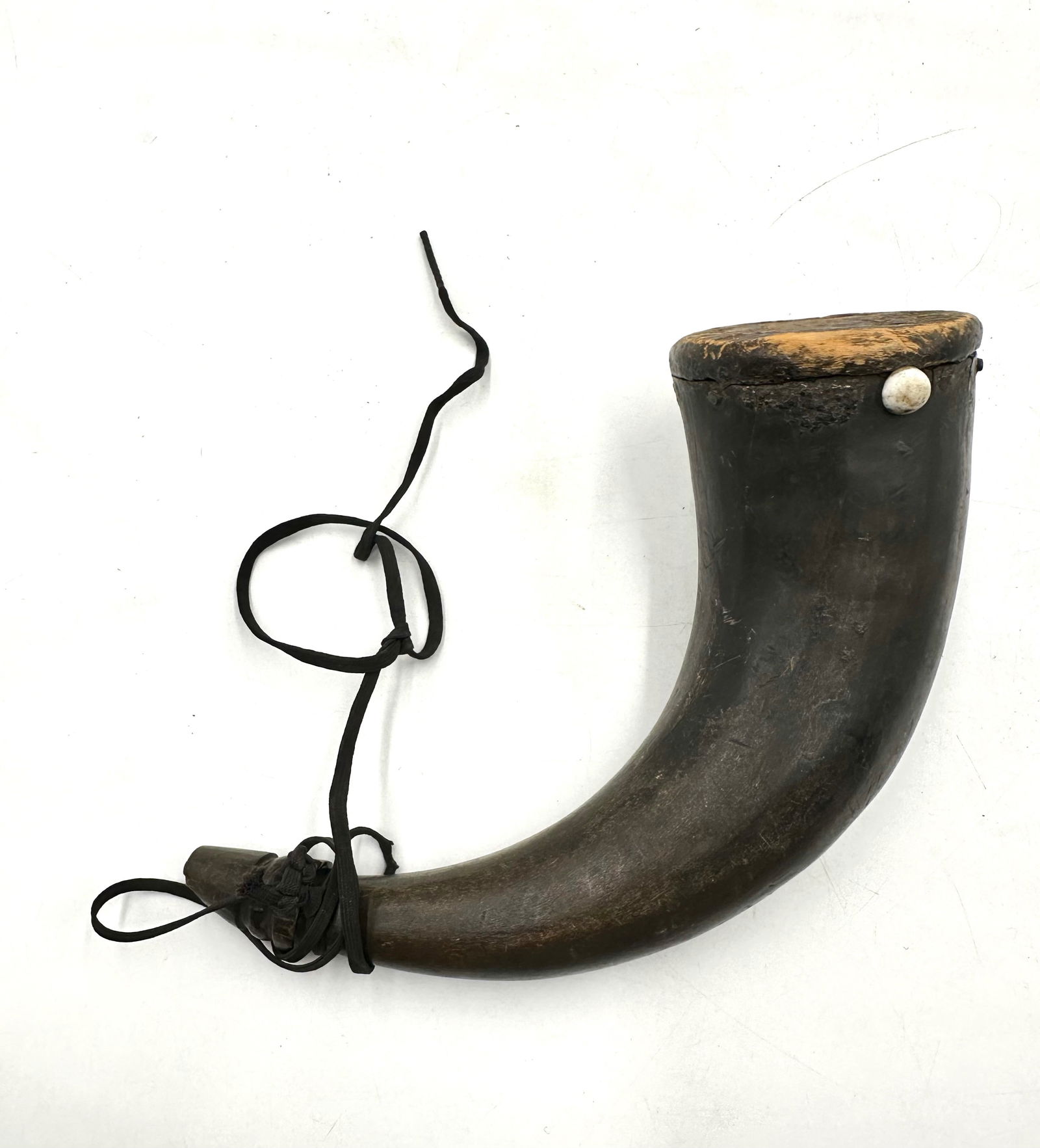 Civil War Black Powder Horn: Hand made powder horn with natural curve to the horn used. Wooden base with lighter coloration on the base but side match in color to the horn itself. The based is attached with white buttons and flat