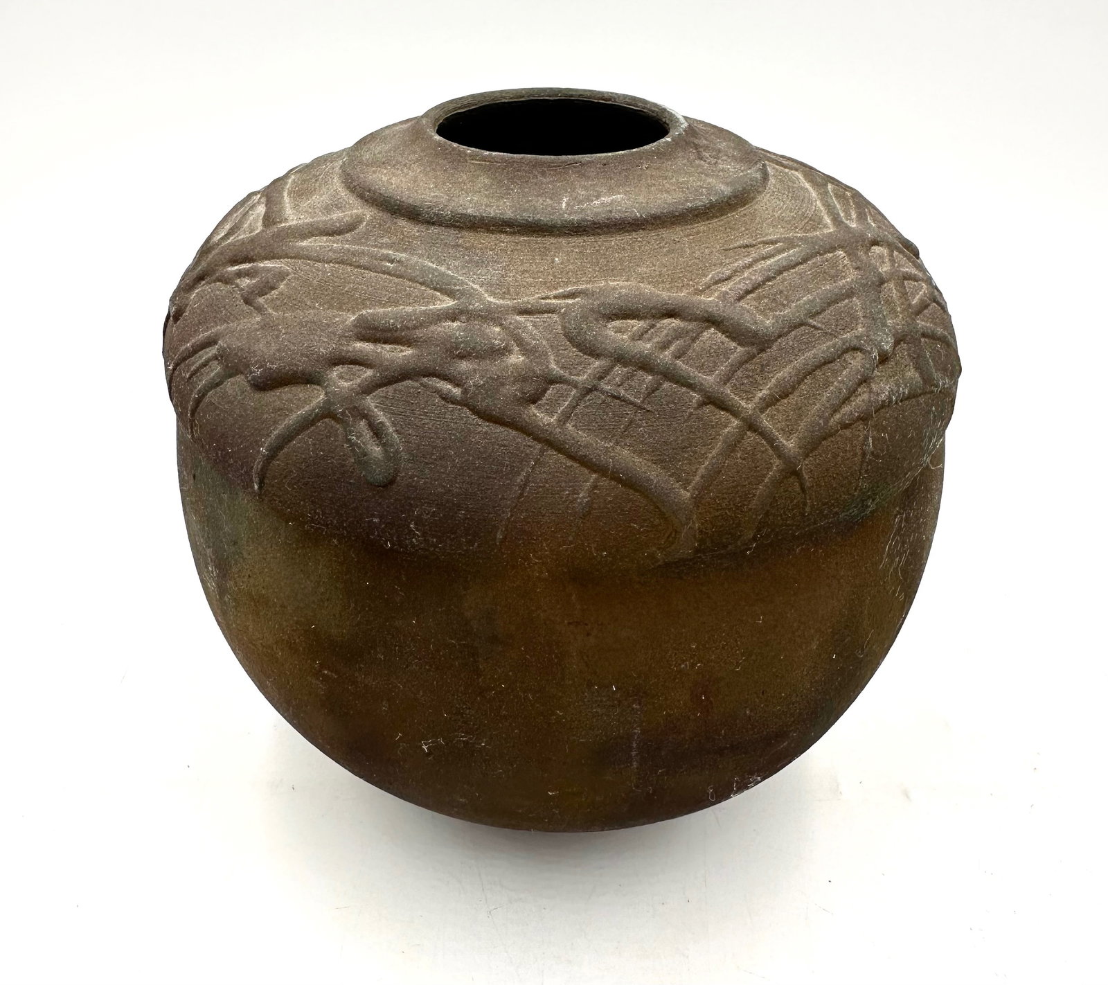 Raku Pot with Slip Design: The hand thrown Raku pot has a wide body and small opening. Along the body there is a at random slip design creating texture and a modern twist. Th piece is signed. Measures 7x7in.