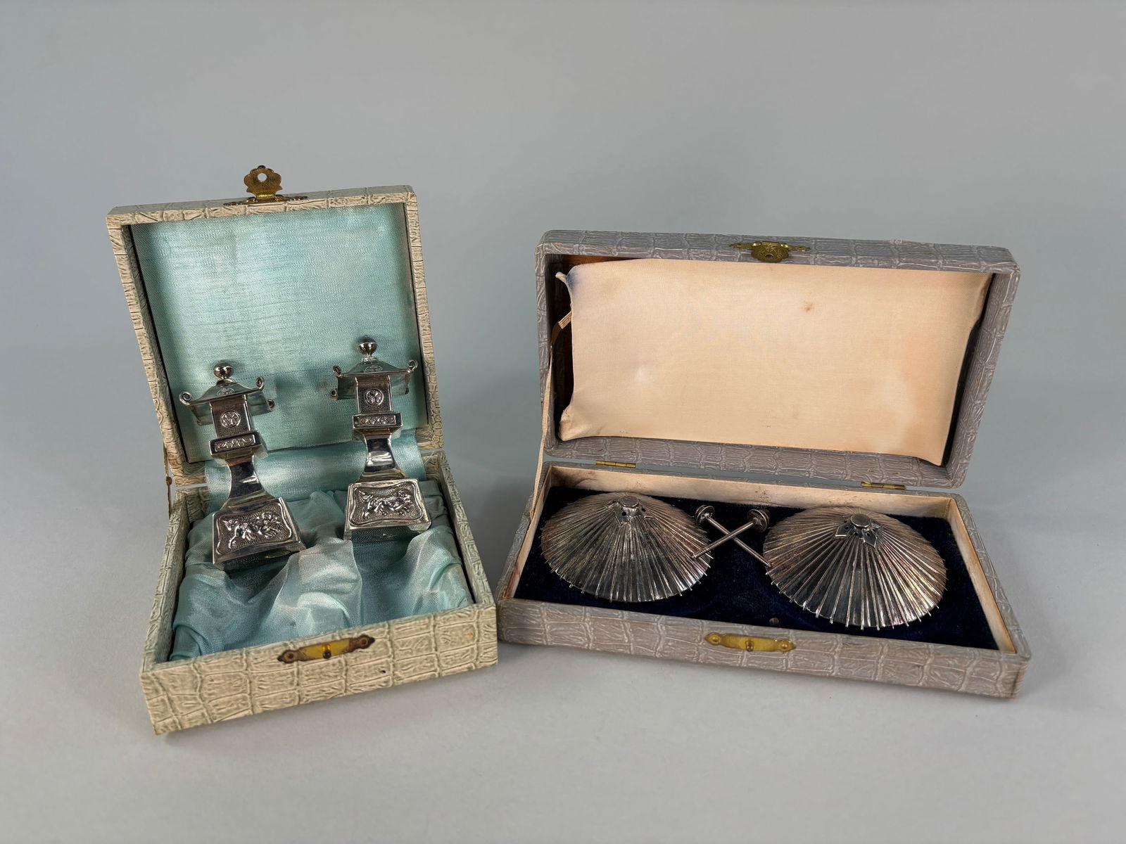 Sterling Silver Japanese Salt and Pepper Shakers: The sets include one pair of standing stone lanterns and one pair of parasols. The stone lantern shakers are stylized with the curling roof design; embossed Mon crests, with a floral mid-section, and