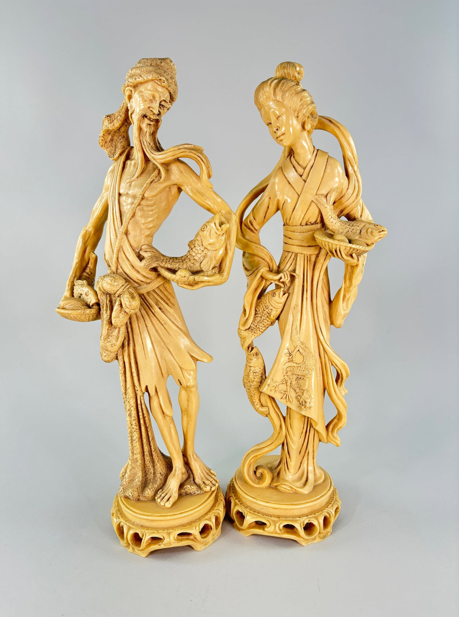 Santini Geisha and Fisherman Couple Sculptures: Two Chinese sculptures by artist A. Santini of a couple. Reportedly both sculptures are made of resin, from the original sculptures were made of alabaster. A Geisha sculpture featuri