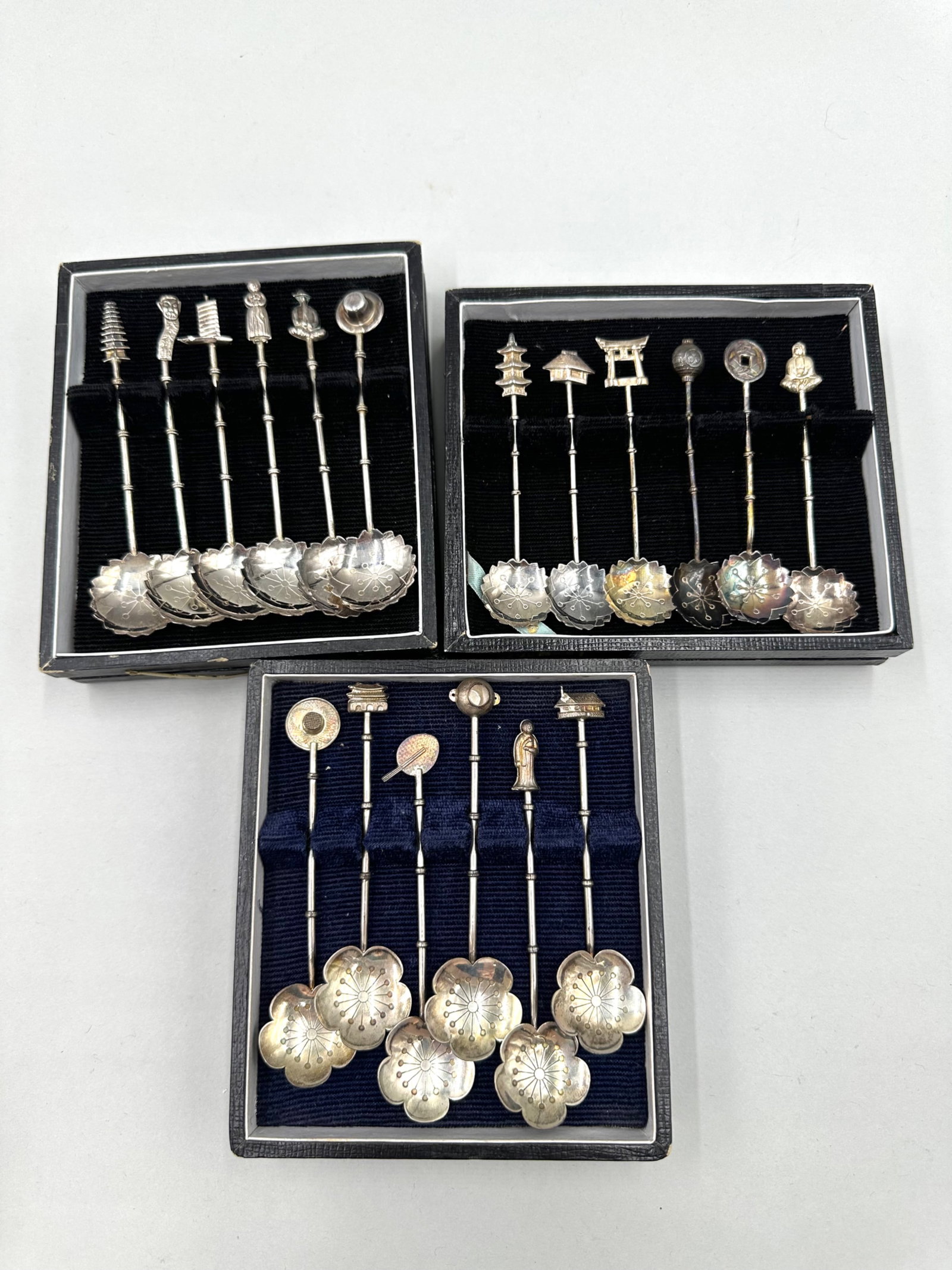Three Sets of Sterling Silver Lotus Spoons: Three sets of sterling silver demitasse spoons each having six spoons in total. Each spoon is stamped "Sterling 950". The bowls of the spoons feature lotus flower designs and the handles are a bamboo 