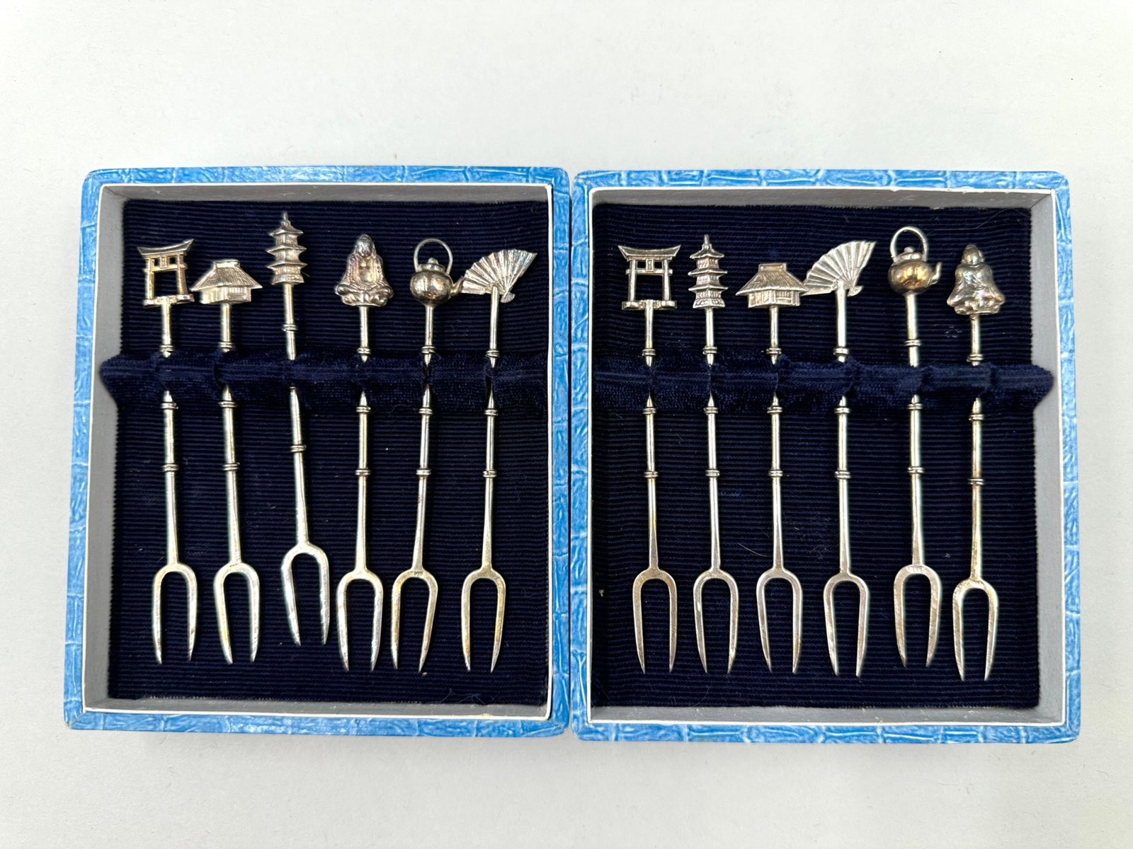 Pair of Sterling Silver Cocktail Fork Sets: Pair of sterling silver cocktail fork sets with each set having six forks each with two prongs. Both sets are marked sterling on the prongs. Both of the sets features handles that are bamboo shaped an