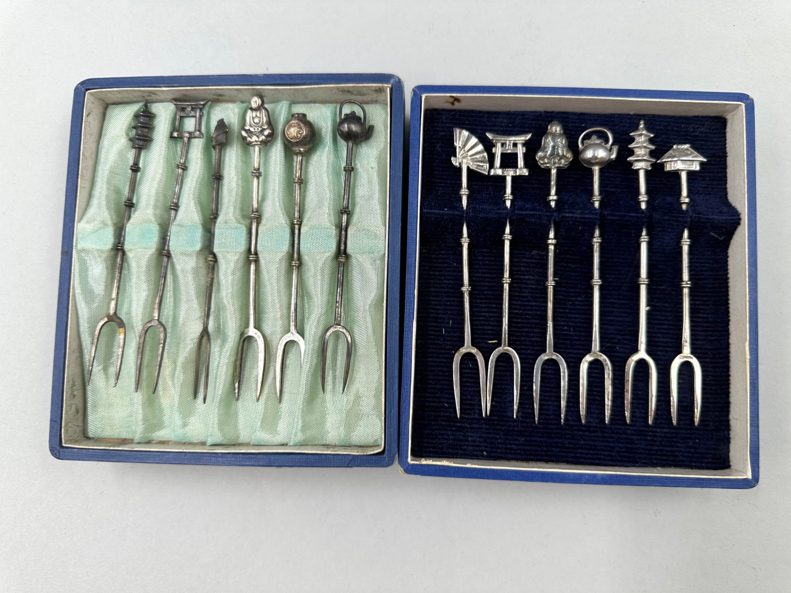 Pair of Sterling Silver Cocktail Fork Sets: Pair of sterling silver cocktail fork sets with each set having six forks each with two prongs. Both sets are marked sterling on the prongs. Both of the sets features handles that are bamboo shaped an