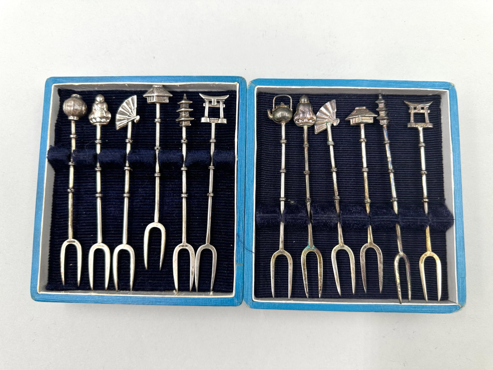 Pair of Sterling Silver Cocktail Fork Sets: Pair of sterling silver cocktail fork sets with each set having six forks each with two prongs. Both sets are marked sterling on the prongs. Both of the sets features handles that are bamboo shaped an