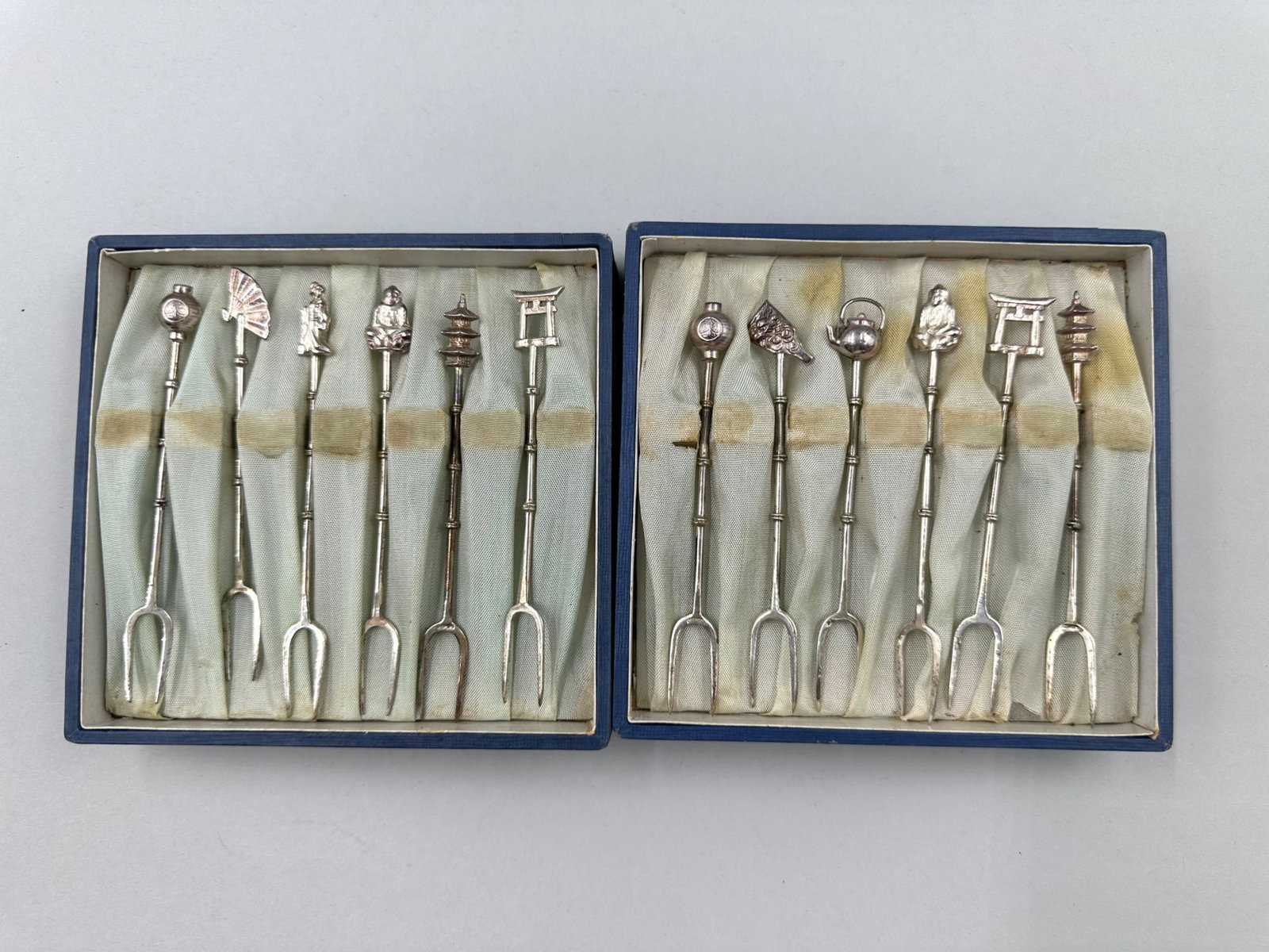 Pair of Sterling Silver Cocktail Fork Sets: Pair of sterling silver cocktail fork sets with each set having six forks each with two prongs. Both sets are marked sterling on the prongs. Both of the sets features handles that are bamboo shaped an