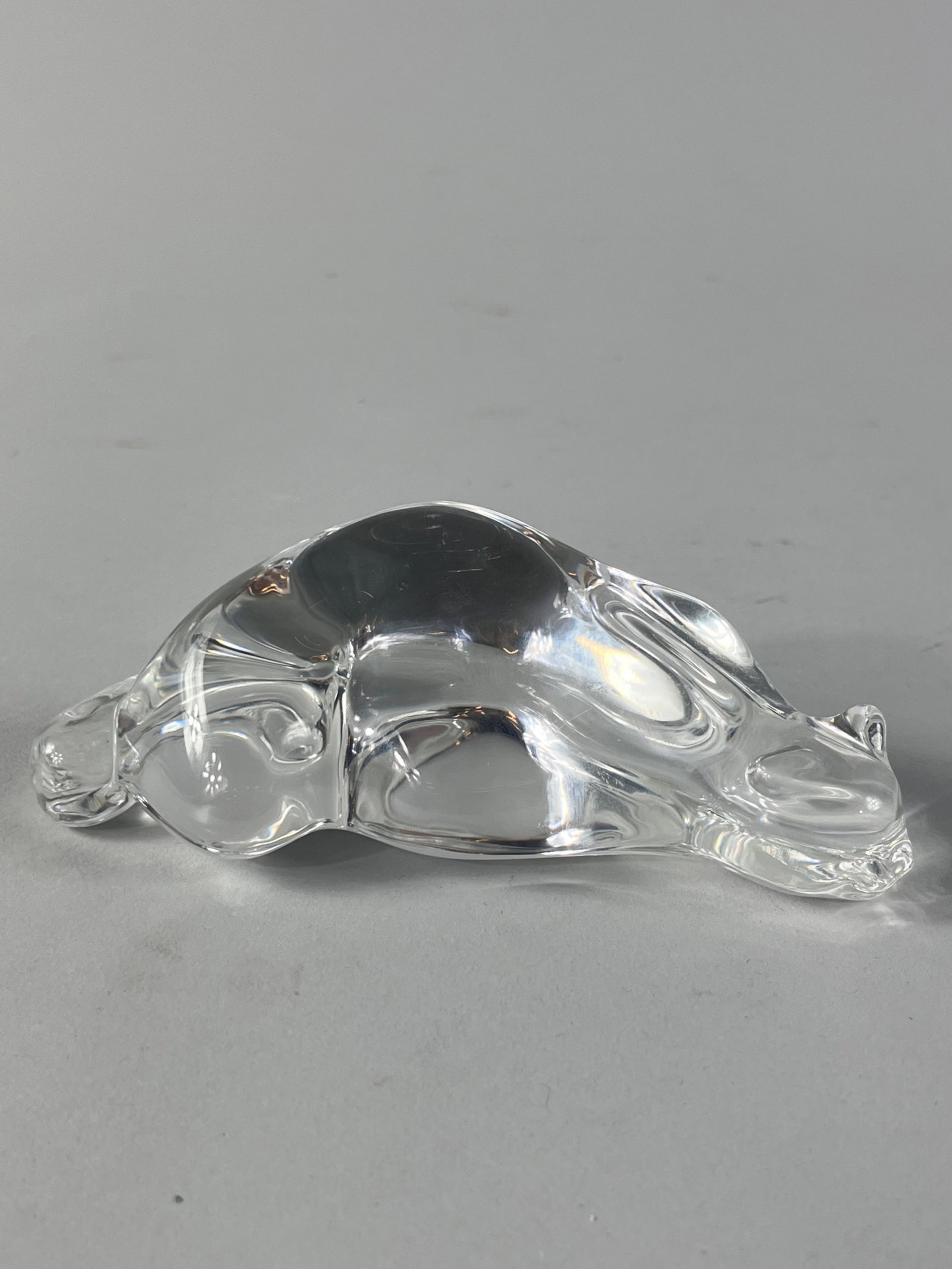 Steuben Crystal Roman Cat: Steuben Crystal Roman Cat designed by Susan Smiley in 1979. The piece showcases a cat in a laid position almost like it is about to either pounce or is taking a nap. Measures 5.25in x 2.5in x 2in An i