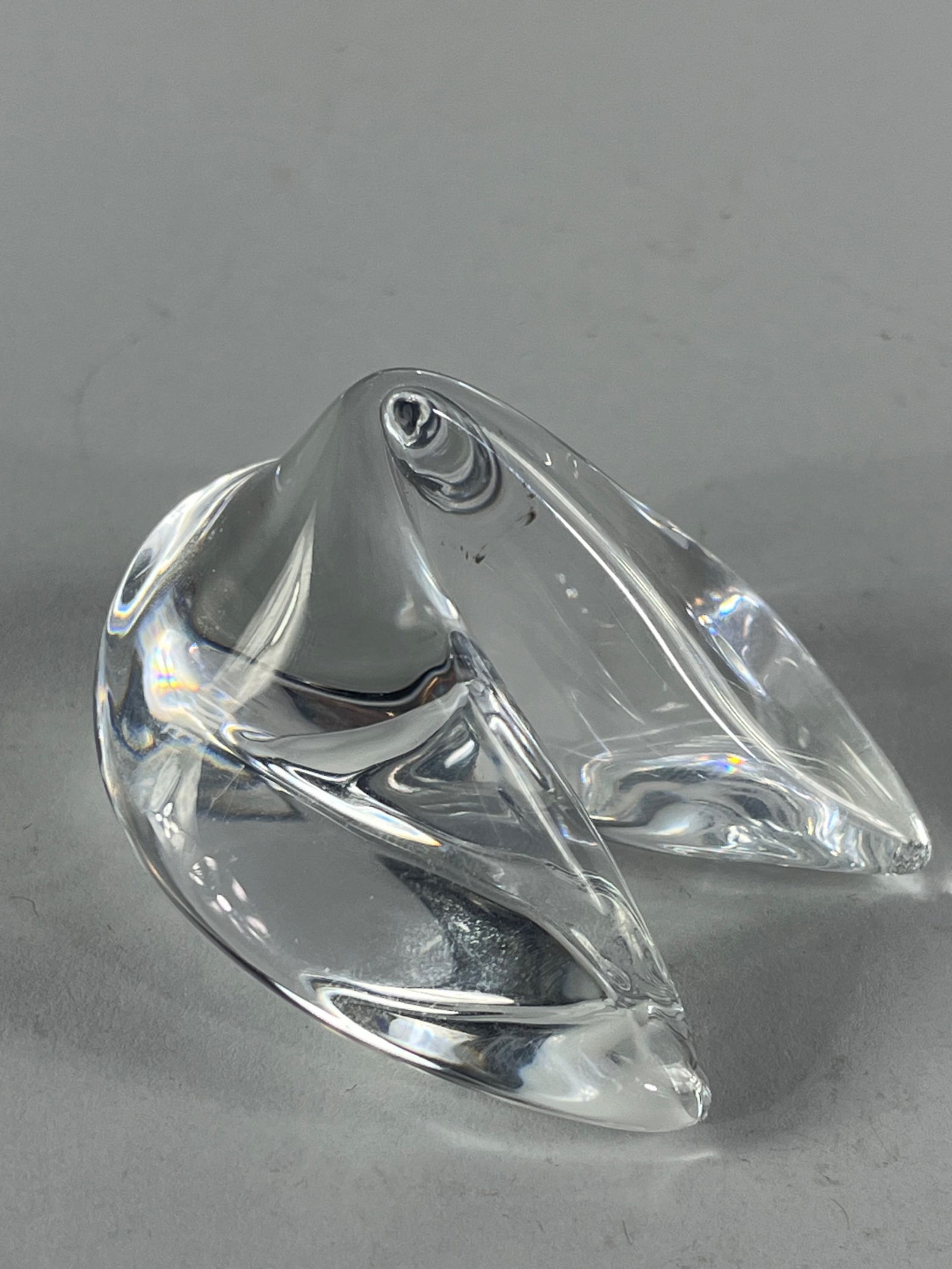 Steuben Crystal Fortune Cookie: Steuben's crystal sculpture in the shape of a fortune cookie. The fortune cookie is etched Steuben on the bottom. Measures 2x3in An in-person inspection is available for all auctions. Blue Box Auction