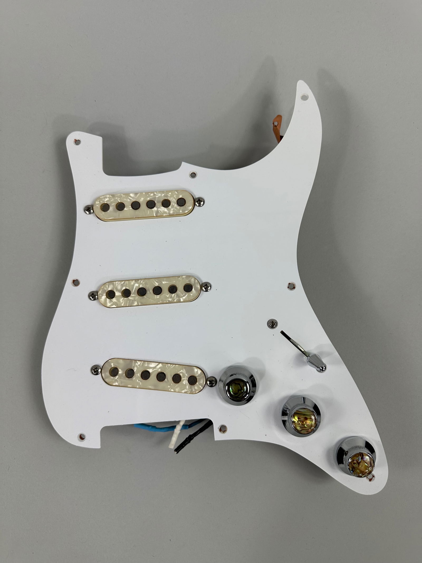 Prewired Stratocaster Assembly: Complete prewired Stratocaster Assembly including a Voodoo Tone Blender with mother of pearl pick ups and knobs. Measures 9x11in An in-person inspection is available for all auctions. Blue Box Auction