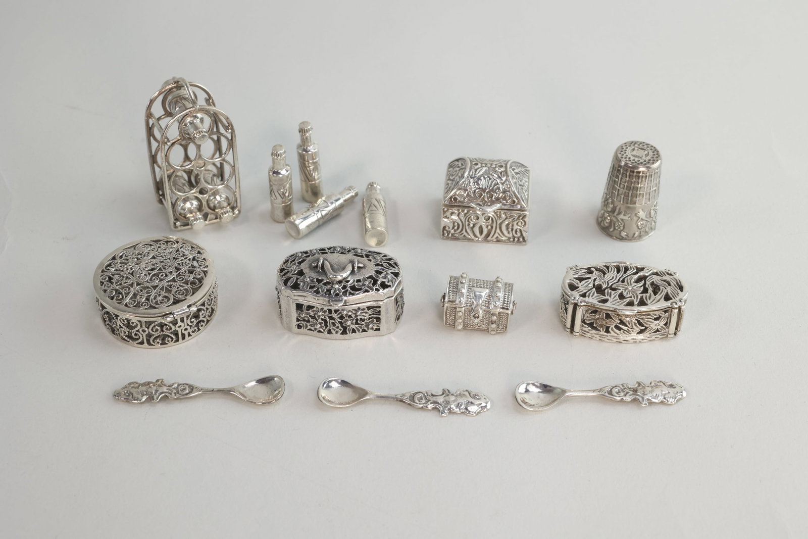 925 Sterling Silver Trinket Boxes and Figurines: There are five boxes and five figurines in total. The first figurine is a wine rack with seven wine bottles that can be removed from the rack. The wine bottles are decorated with triangles. The wine r