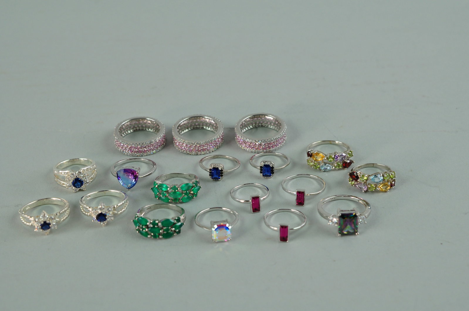 925 Sterling Silver Rings Bracelets and Earrings: Thirteen 925 stamped rings decorated with tourmaline gemstones. Three of the rings have pink tourmaline and clear glass stones. Five rings have dark blue and clear tourmaline stones. Three of the ring