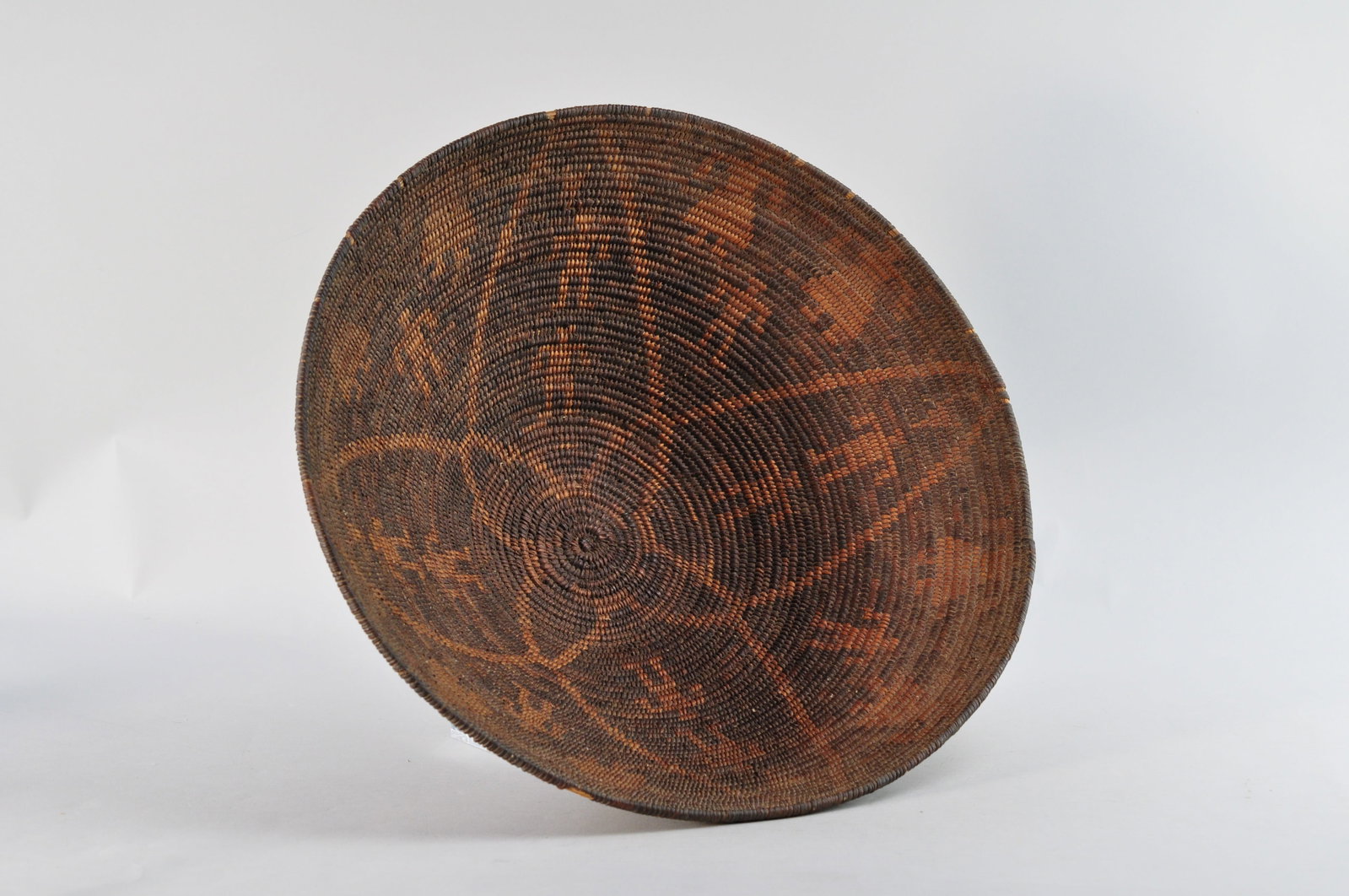 Akimel O'odham Pima Woven Basket: An Akimel O'odham Pima woven bowl basket. The basket has a rounded open shape with a coiled structure. It is believed to have been made in the early 20th century and within the regions of Arizona or N