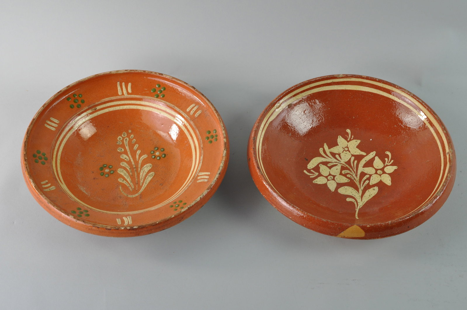 Two Antique Redware Glazed French or Portuguese Bowls: Two redware bowls, believed to be antique redware glazed Swizz, French or perhaps Portuguese Bowls. Believed to have been made in the 1800s. One bowl has a low round shape wi