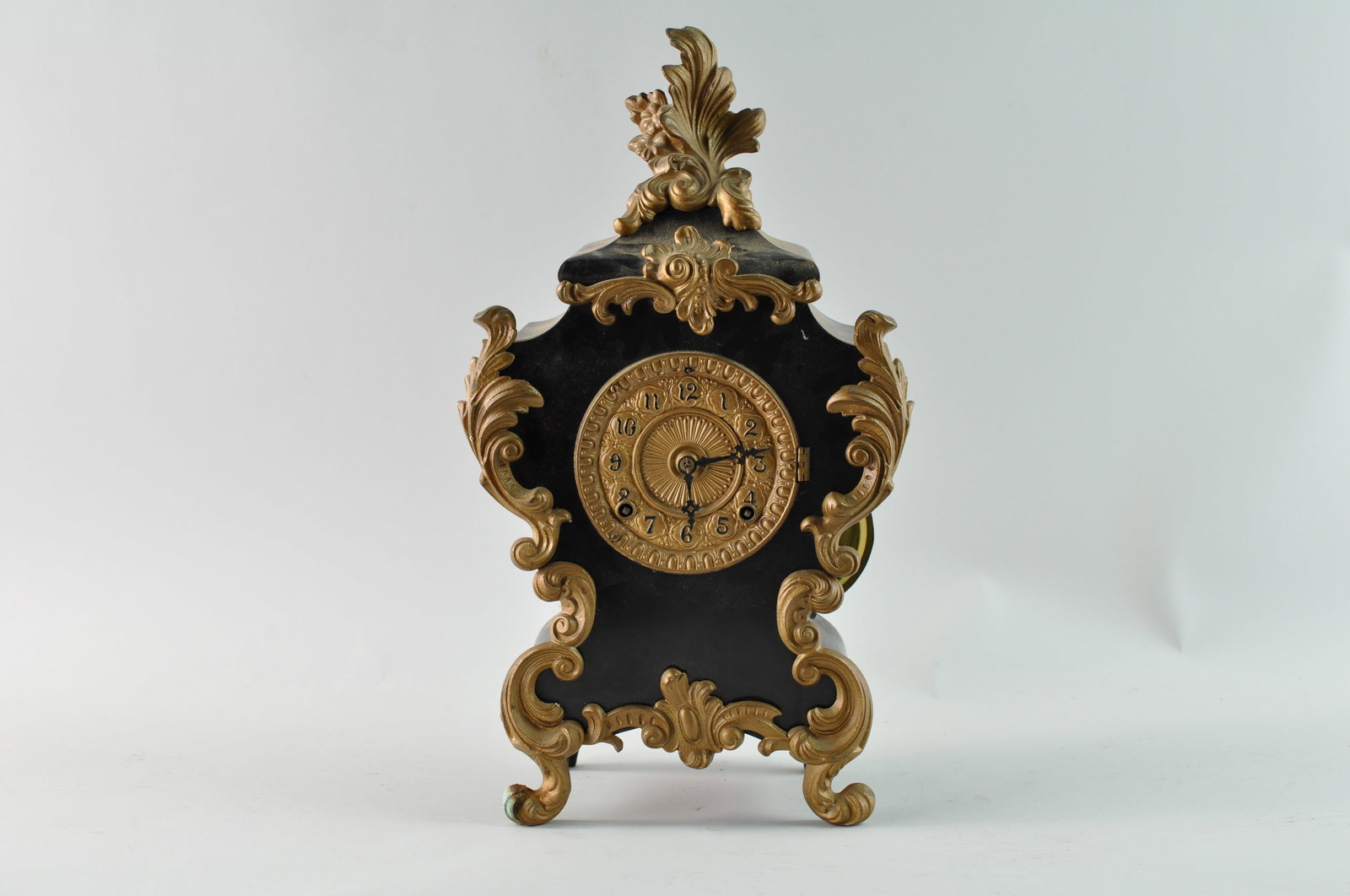 Ansonia Rococo Style Mantel Clock, Late 19th Century: Late 19th Century New York Ansonia Clock Co. mantel clock. The company name is stamped on the gears inside of the clock. The clock has a Rococo style with black metal and ornate gold tone mounts. The