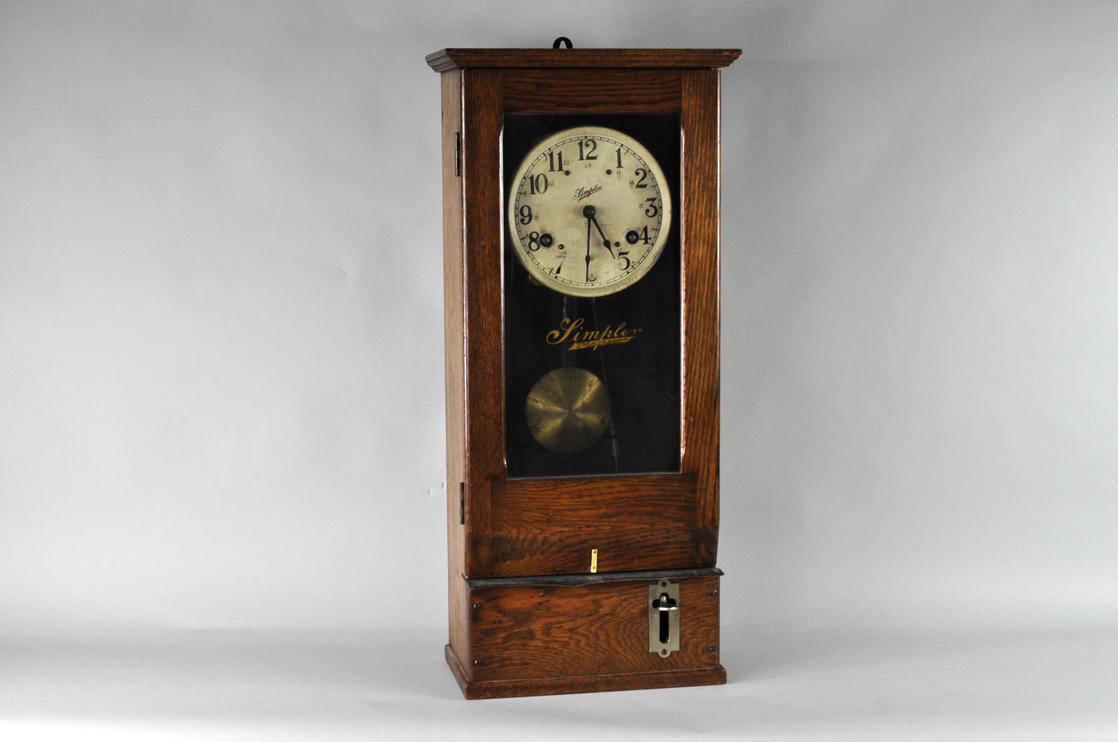 Simplex Wooden Case Wall Clock: The wall clock is believed to be from the early 1900s, pre 1930s. The wall clock has a round white face marked "Simplex, Made by Simplex Time recorder Co. Gardener Mass. U.S.A" and the glass door is a