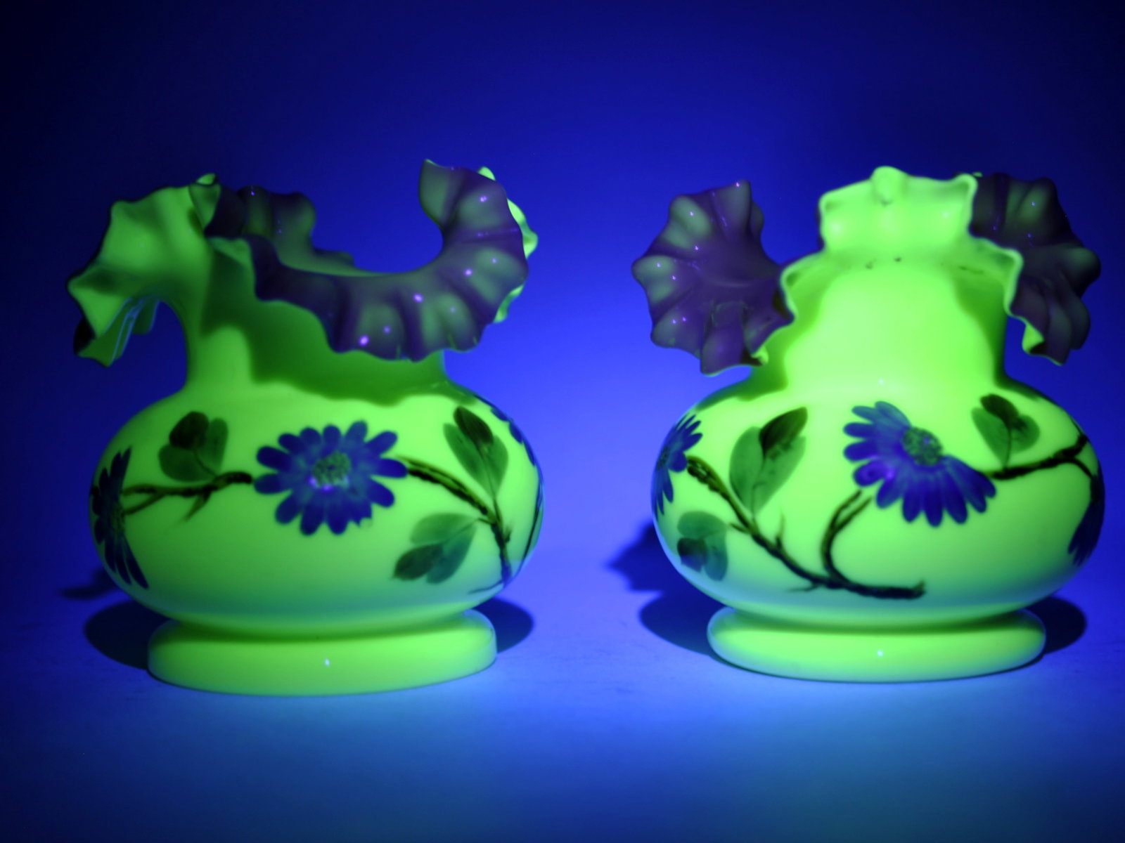 Uranium Glass Vases w/ Pink Ruffled Rim: Dimensions: Approx. 5x4 1/2" Condition: No Visible Damage Additional Information: Pair of hand-blown cased glass vases featuring vibrant uranium green body that glows brilliantly under