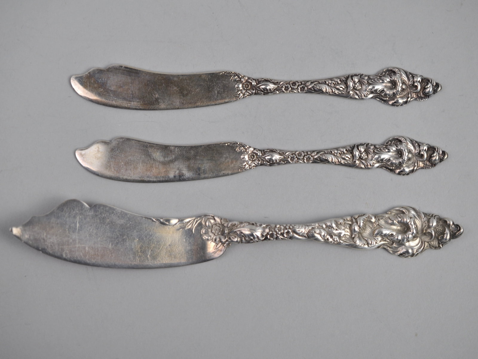 Reed Barton Les Six Fleurs Sterling Butter Knives: ?Metal: Sterling Silver Manufacturer:?Reed & Barton Dimensions:?Various Weight:??3.04 ozt Condition: Light to Moderate Patina