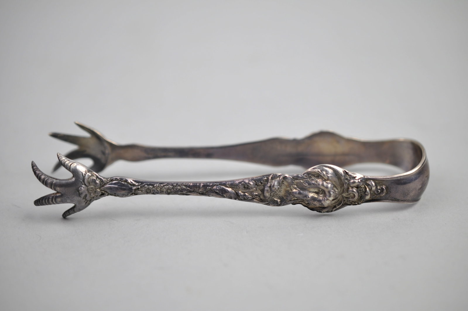 Reed Barton Les Six Fleurs Sterling Sugar Tongs: ?Metal: Sterling Silver Manufacturer:?Reed & Barton Dimensions: 1/2" Weight:? 3.04 ozt Condition: Light to Moderate Patina