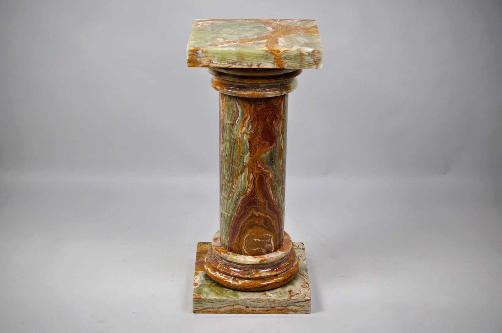 Banded Onyx Pedestal/Pillar: Dimensions:?Approx. 14x14x32" Condition:?Some?Chips and Scratches? Additional Information:?A striking contemporary pedestal crafted from banded onyx, featuring vibrant orange, red and?green tones