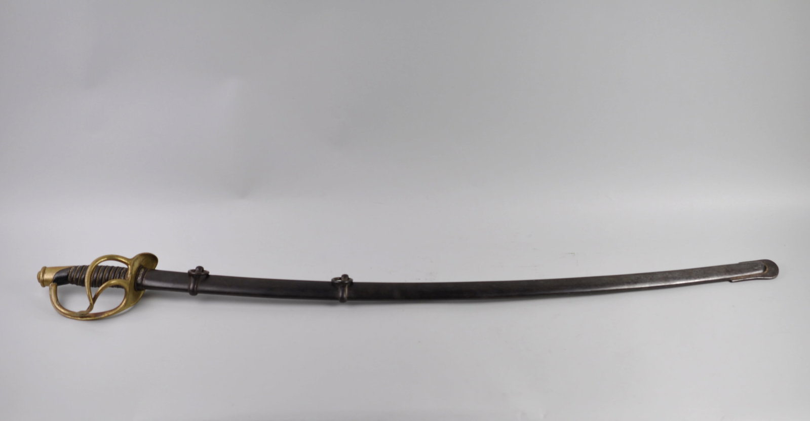 US Model 1860 Cavalry Sword and Scabbard: Manufacturer: Ames Co.- Inspected by George W. Chapin Dimensions: Approx. With Scabbard: 42 3/4" Condition: Blade and Scabbard have Rust. Chipping to Blade Believed from Use in Combat.
