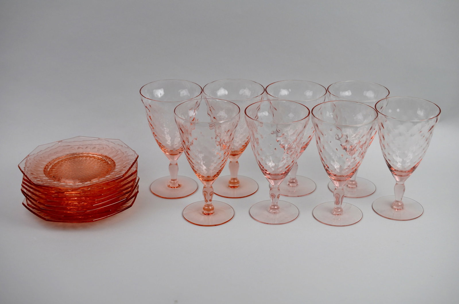 Pink Depression Plates and Glasses: Dimensions: Glasses: 3 1/4X6 in. Plates: 6x6 in. Condition: Light Scratches May Be Present Additional Information: This pink depression glass collection includes a selection of matching plates and
