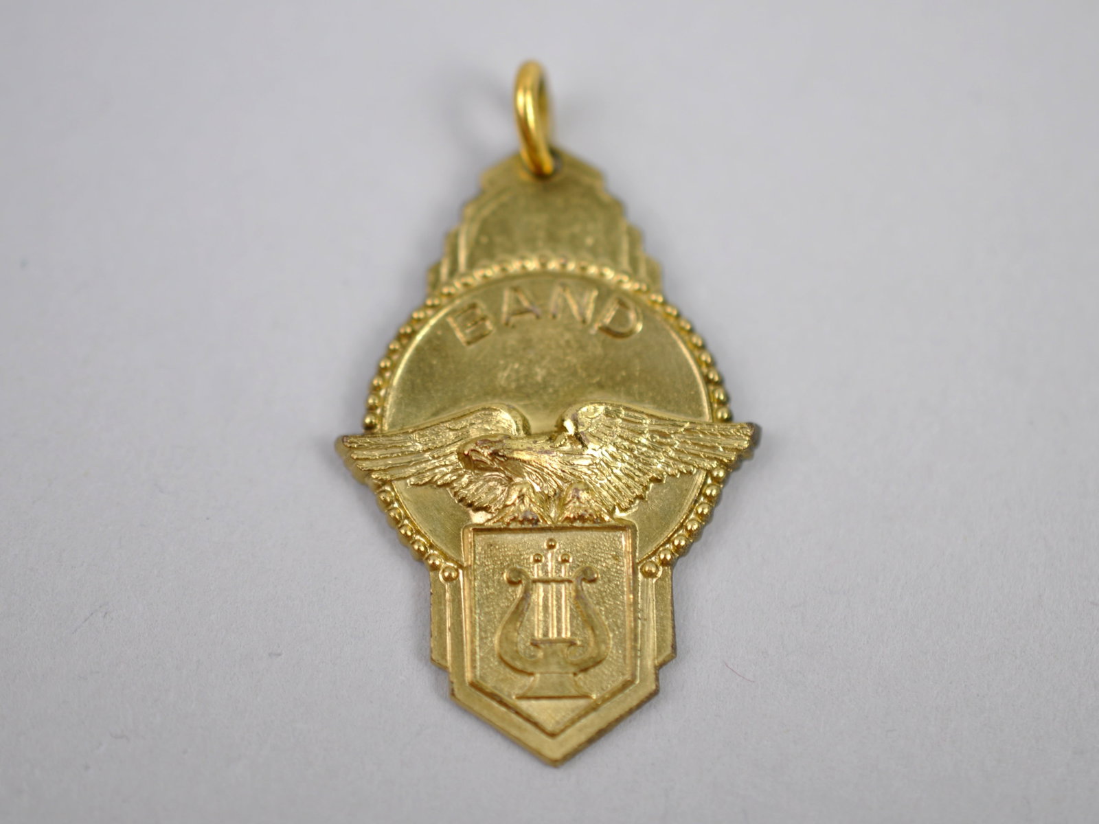 Jostens 14K Gold Eagle Pendant "BAND": Brand: Jostens Metal: 14K Yellow Gold Stone Types: N/A Dimensions: Approx. 1.25 in. Weight: Approx. 0.16ozt Condition: No Visible Flaws Additional Information: Vintage Jostens 14K yellow gold