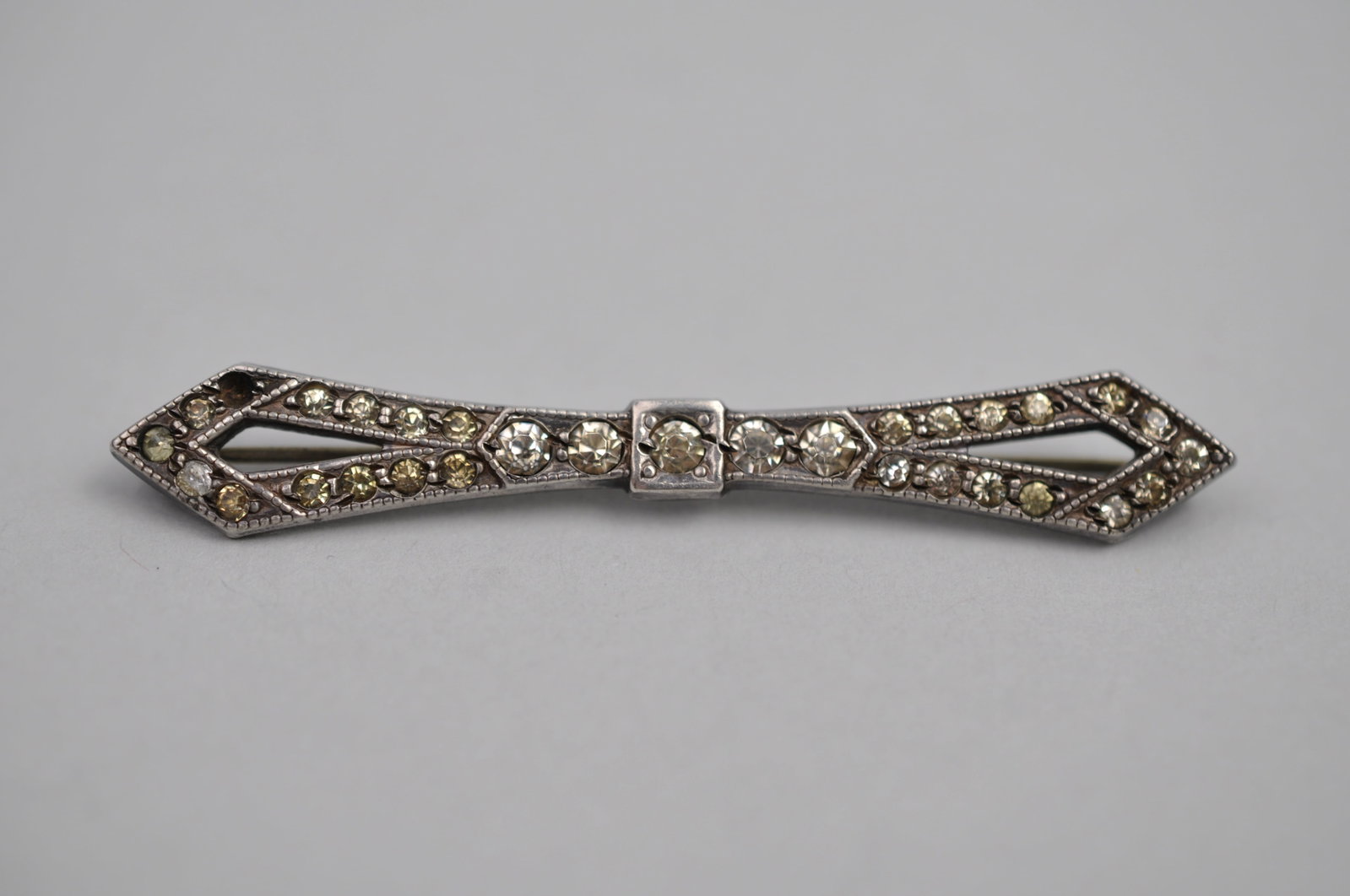 Sterling Silver Art Deco Brooch: Metal: Sterling Silver Stone Types: Tested Stones in Tourmaline Range (unverified), One Accent Stone Missing Dimensions: Approximately 2.5 in. Long Weight: 0.21ozt Condition: Good Vintage Condition;