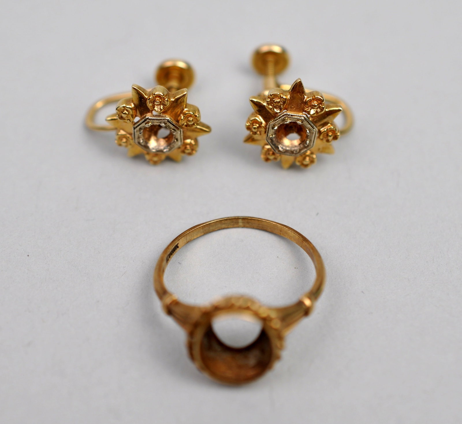 10K Gold Earrings & Ring Setting: Metal: 10K Yellow Gold Stone Types: Empty Mountings (center stones missing) Dimensions: Ring size 5.5; screwback earrings approximately 0.5 in. diameter Weight: 0.14ozt combined Condition: Missing