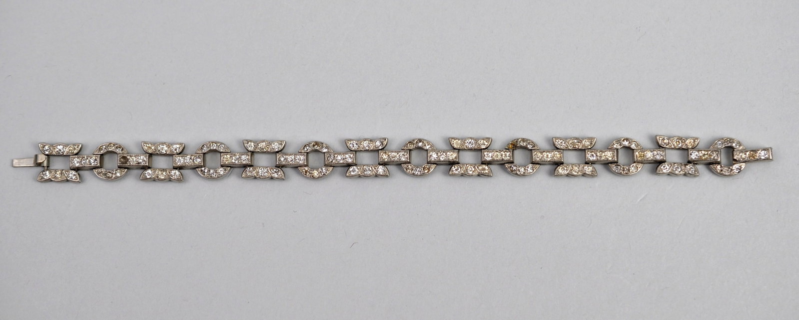 Rhodium Plated Rhinestone Bracelet: Metal: Rhodium-Plated White Metal Stone Types: Clear Glass Rhinestones Dimensions: 8 in. bracelet length Weight: 0.49ozt Condition: Surface wear consistent with age and use, one stone missing.