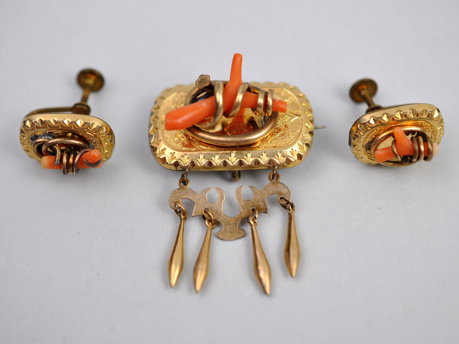 Gold Tone Coral Brooch Earrings: Metal: Gold-Tone Metal Stone Types: Branch Coral Dimensions: Brooch approximately 1.5 in. wide; matching screw-back earrings Weight: 0.49ozt Condition: Surface wear consistent with age and use.