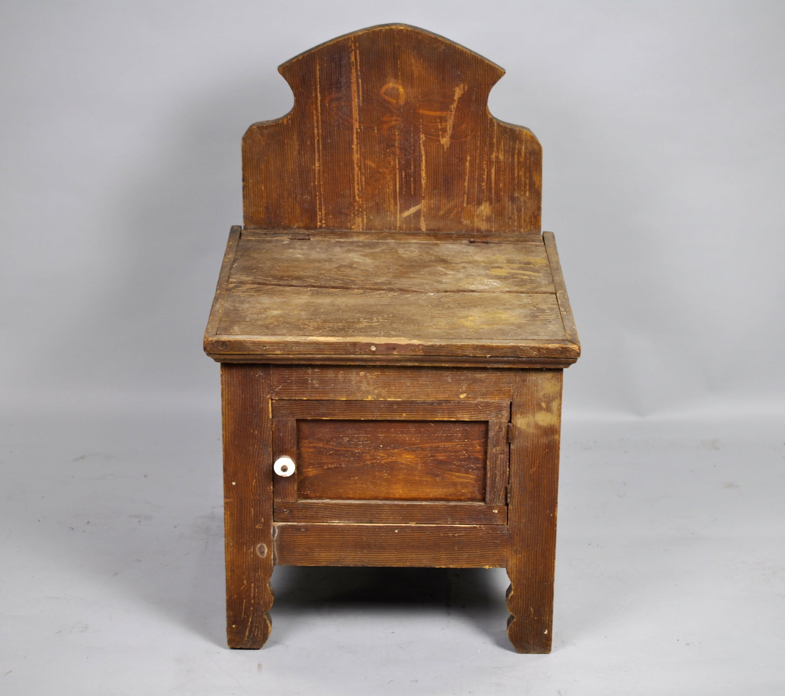 Primitive Wooden Bedside Commode: Manufacturer: Unknown, unmarked Period: Late 19th Century to early 20th Century Dimensions: 18 1/2 x 17 1/2 x 30 in. Condition: The overall frame looks intact and stable. Wood shows heavy patina,