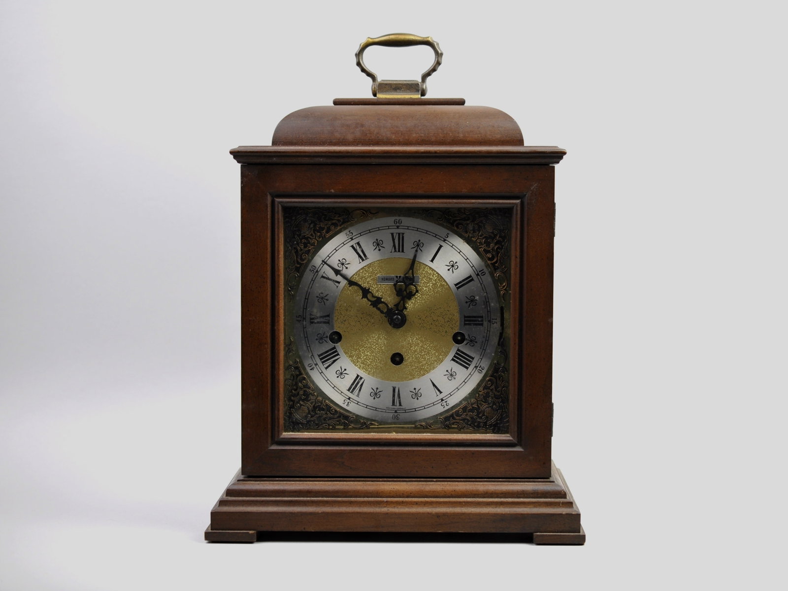 Howard Miller Mantel Clock with Keys: Origin: West Germany(Jewels)/Michigan(Clock) Dimensions: Approx. 9x6 1/2x15 in. Condition: Untested, No Visible Signs of Damage Additional Information: A Howard Miller mantel clock represents a blend