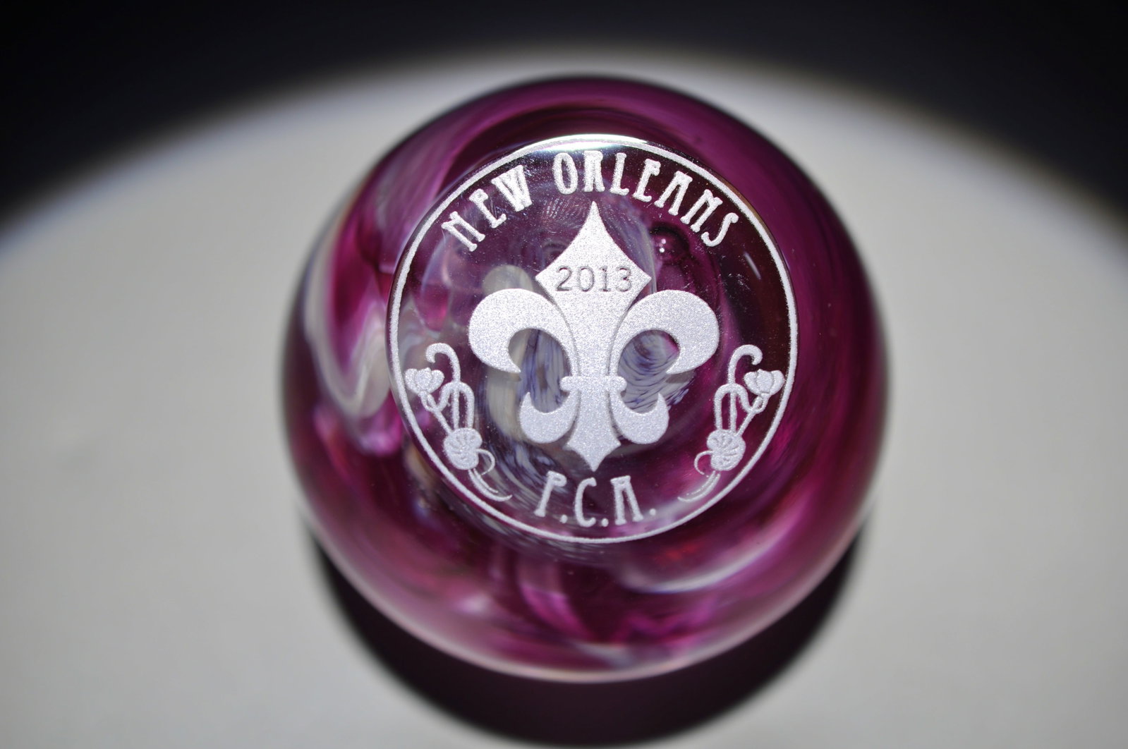 P.C.A. 2013 New Orleans Swirl Paperweight: Attributed Brand: PCA New Orleans Period: 2013 Style: Latticinio, (signed, near base) Base: Clear Diameter: 2.44 in Weight: 0.76 lb Condition: Base wear Additional Information: An etched fleur-de-lis 