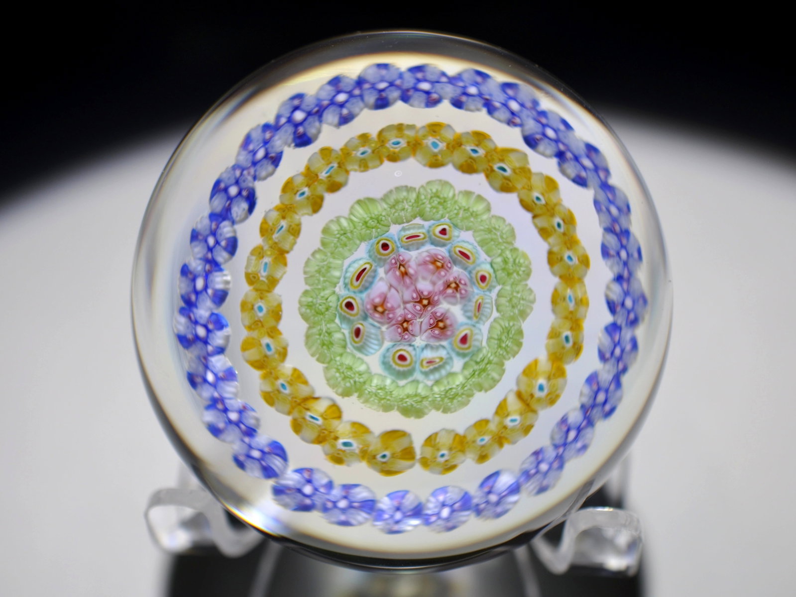 Baccarat Concentric Millefiori Paperweight: Attributed Brand: Baccarat Period: 1960s-1980s Style: Millefiori, Garland Base: Clear Diameter: 2.55 in. Weight: 0.78 lb Condition: Base Wear. Additional Information: A central cluster of complex
