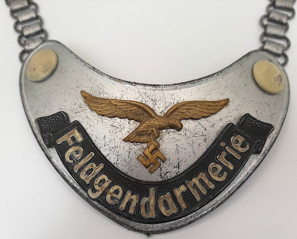 WW2 GERMAN LUFTWAFFE Feldgendarmerie GORGET LW ASSMANN: LW Feldgendarmerie gorget. Identical to the regular, very common gendarmerie gorget except it features the LW eagle.LW Feldgendarmerie gorget. The gilt eagle has lost most of its fluorescent coating b