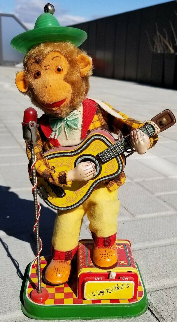 VINTAGE MONKEY GIBSON GUITAR MICROPHONE TIN TOY 1950s: A VERY RARE MINT CONDITION - WORKING CONDITION BATTERY OPERATED MONKEY GUITAR PLAYER AND SINGER. IT COMES WITH THE HAT WHICH IS ALWAYS MISSING. IT PLAYS GUITARS, TAP HIS FEET AND SWING! A MUST TO ADD 