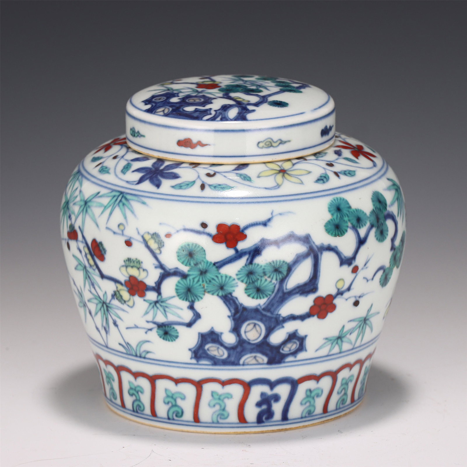 A CHINESE DOU-CAI GLAZED FLORAL PORCELAIN JAR AND COVER: H. 14 cm. W. 13 cm.