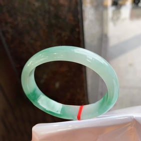 A Chinese Carved Jadeite Bangle