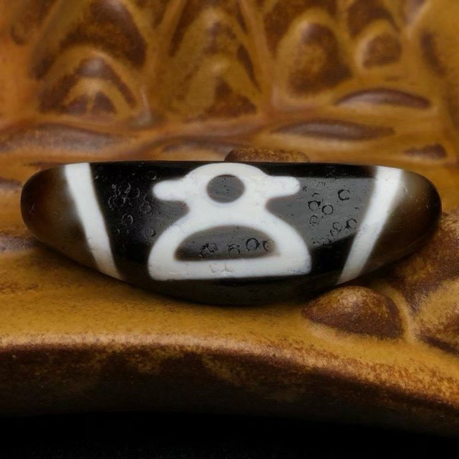 A Chinese Carved Agate DZI Bead: Lg. 5cm, Diam. 1.7cm, Th. 1.1cm, Wt. 15.6g