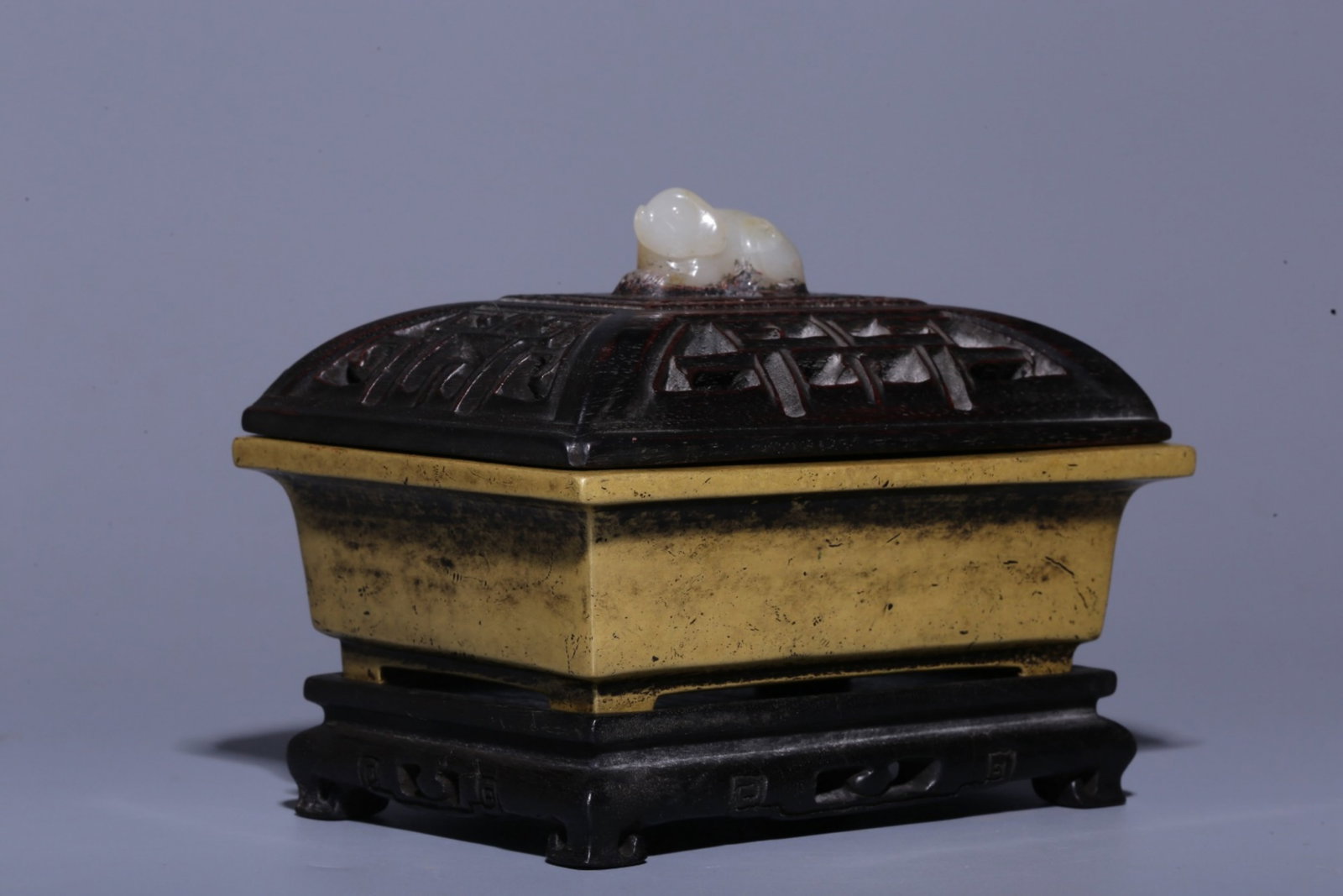 A Chinese Gilt Bronze Incense Burner with Carved Hardwood Lid, Stand, and Jade Handle: Ht. 11cm, Lg. 13.2cm, Wd. 9.8cm, Wt. 1039g