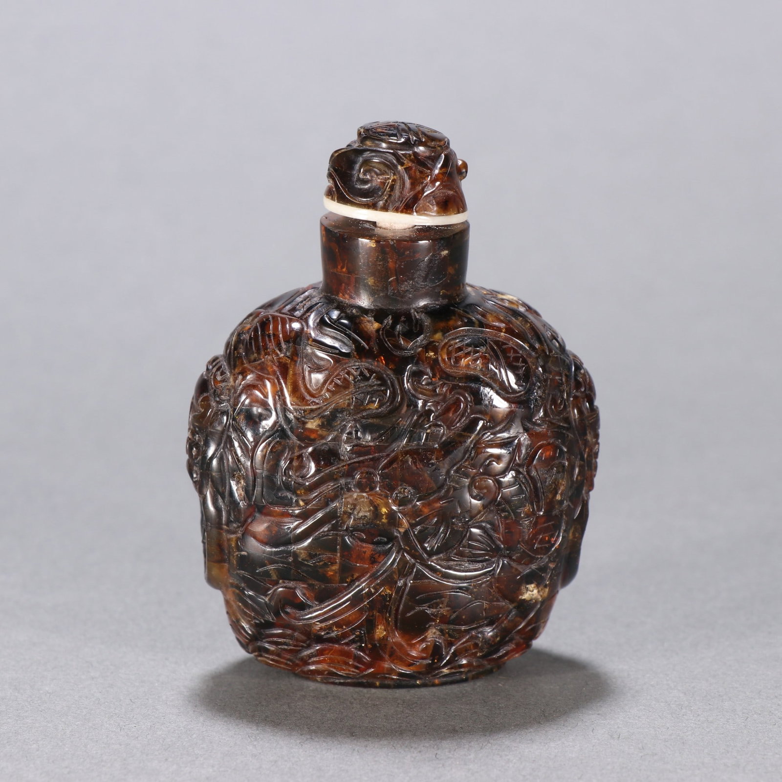 A Chinese Carved Amber Snuff Bottle: Ht. 7cm, Wd. 5.2cm, Wt. 28.5g