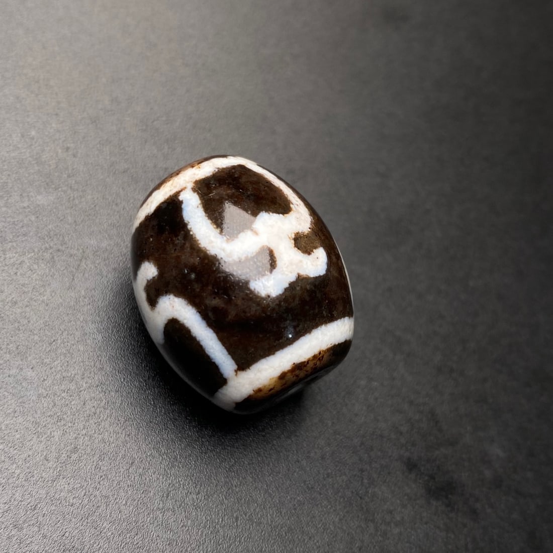 A Chinese Carved Agate DZI Bead: Lg. 2.1cm, Diam. 1.8cm, Wt. 10g