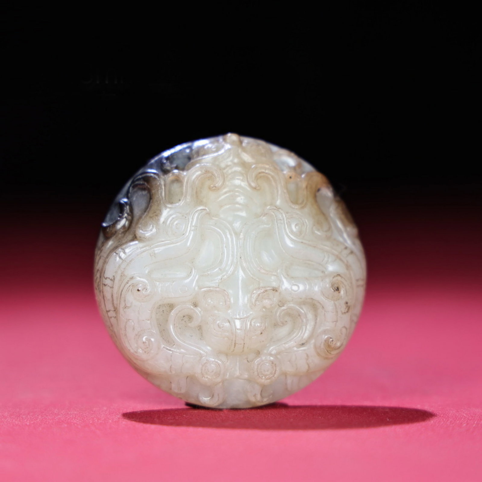A Chinese Carved Jade Foo-Dog Pendant: Diam. 5.4cm, Th. 1.3cm, Wt. 59g